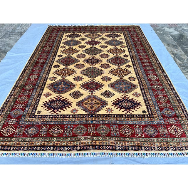 This magnificent hand-knotted wool area rug showcases an authentic, highly detailed Afghan Kazak tribal style. The large...
