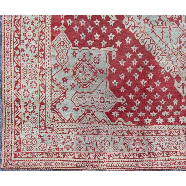 Antique Turkish Oushak rug in delicate red background and light blue border, Rug / , Antique Oushak Circa 1910 This lovely...