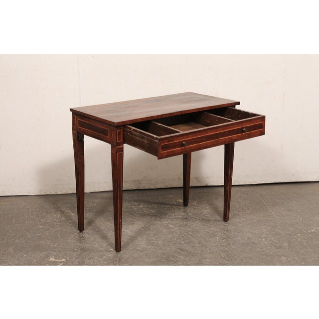 An Italian smaller-sized wooden console table, with satin wood inlay and veneers, from the 19th century. This antique...