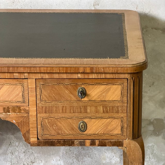 Rounded legs with faux fluting Curved legs. Features side shelves and a green leather top. Minor veneer lifting and sun...