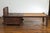 An antique Javanese teak wood daybed from the 19th century, with rattan seat, storage and hand carved scrolling motifs....