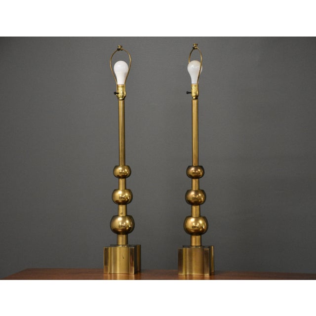 A pair of mid century vintage brass table lamps made by Stiffel. Height is measured to the top of the finial. Lamp shades...