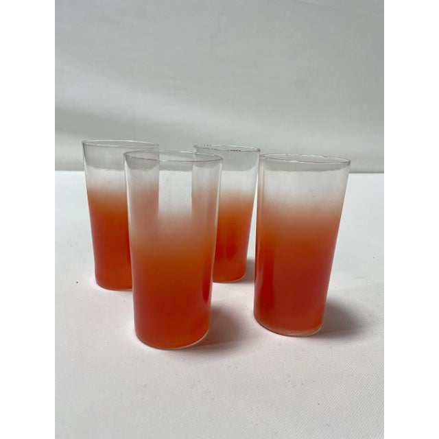Set of 4 Mid-Century Bendo Faded Orange Tumblers that are unmarked. There is a faded gold rim on each glass that is...