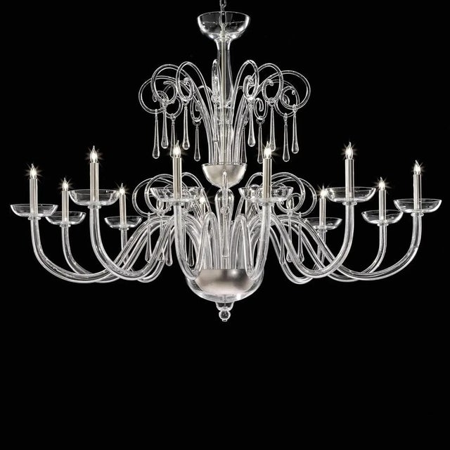 Elegant and sinuous chandelier in trasparent blowing Murano glass and chromed metal frame. Shenographic italian chandelier...