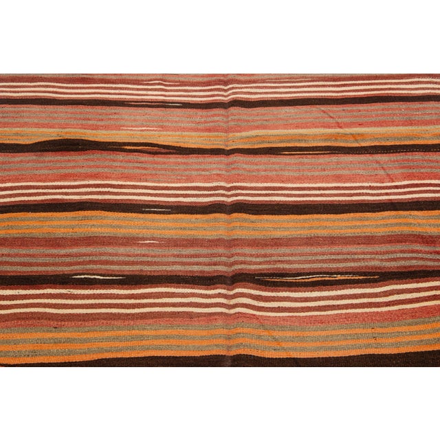 Beautiful Vintage Kilim hand-knotted wool rug with a multicolor accents in an all-over geometric stripe design. This rug...