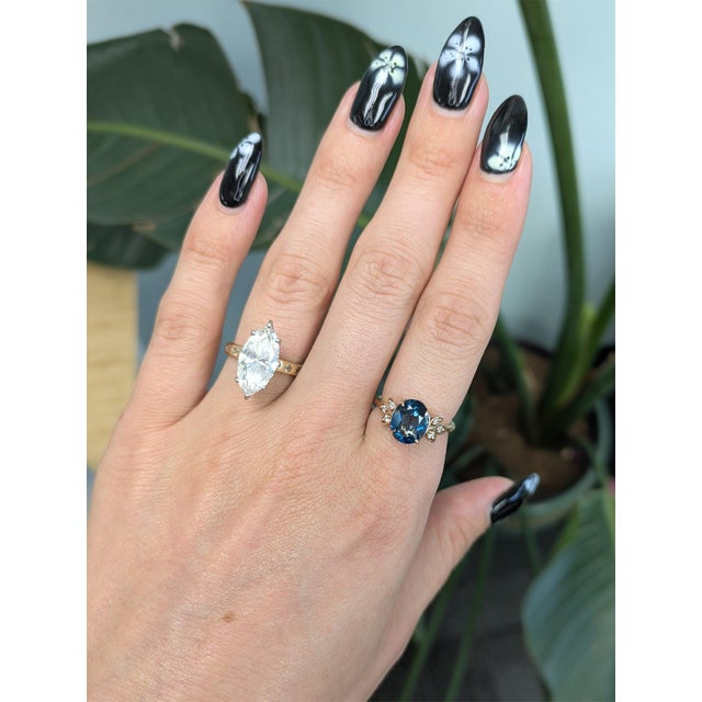 A 3.25-carat London blue topaz pools with deep, inky blue at the centre of this solid 14K rose gold ring, accented by six...