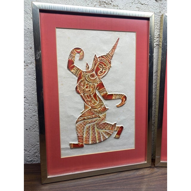 Pair of vintage Thai temple rubbings. Red ink on rice paper. Professionally framed in gold metal frames with red mats....