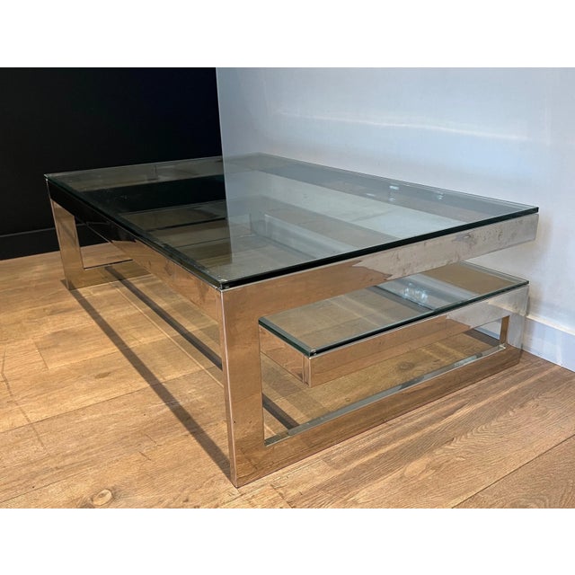 This design coffee table is made of chrome with 2 thick glass shelves. This is a French work, circa 1970.