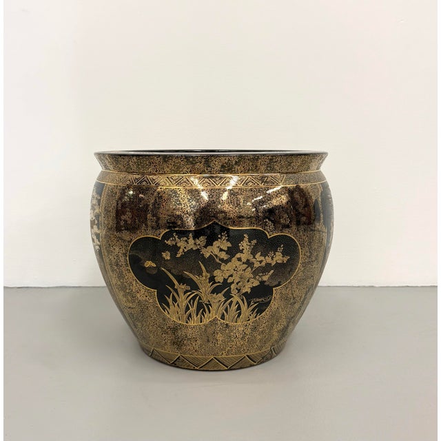 An elegant vintage Chinoiserie cachepot featuring a rounded silhouette with richly detailed black and antique gold...