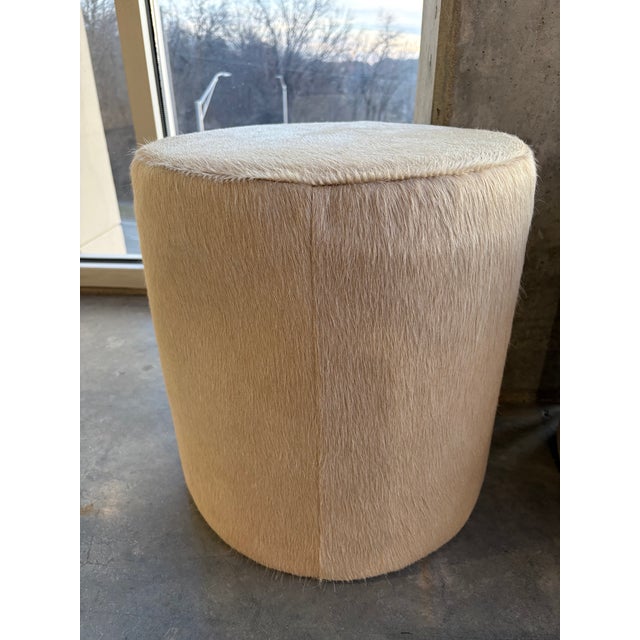 Pair of Hair on Hide Round Ottomans Genuine cow hide fur and wood round poufs Originally from Charlie Leather One of the...
