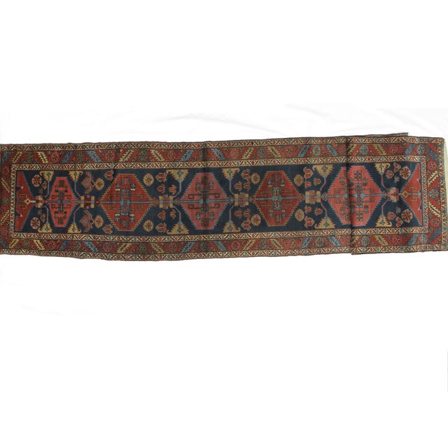 A plush wool pile and a deep, jewel-tone color palette lend this handmade, antique Persian Serapi runner a classic look...