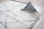A 5' 7" x 8' 7" hand-knotted wool rug with an ivory Berber-style field crossed by irregular charcoal lines, with a lightly...