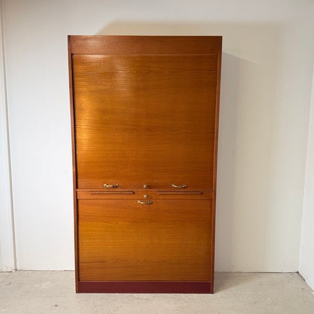 Stunning and mechanically ingenious mid-century tambour cabinet, a prime example of high-quality German office design. The...