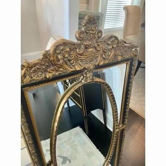Offered is a vintage Hollywood regency style mirror with beveled glass. This black and gold gilt mirror offers a timeless...