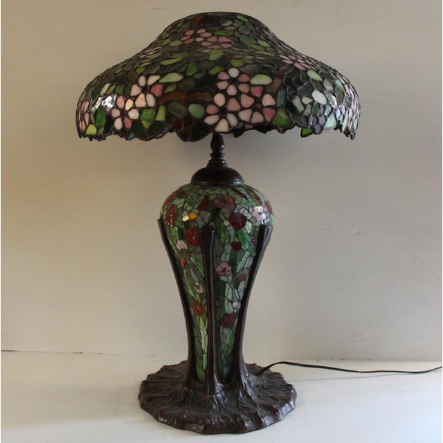 This 20th century Tiffany-style desk lamp is supported by a sturdy, heavyweight bronze base. The lampshade itself, the...