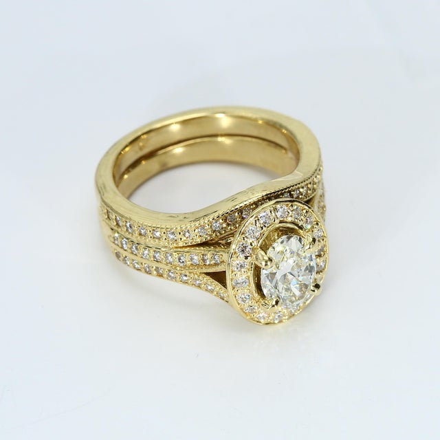 This exquisite engagement ring is a masterpiece of elegance. Crafted in 18k yellow gold, it features a stunning oval white...