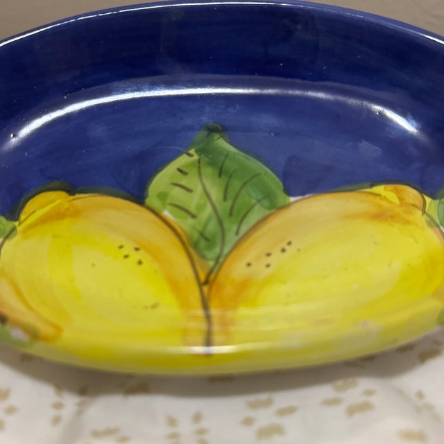 Add a pop of color to your space with this charming oval-shaped trinket dish. Featuring bright yellow lemons against a...