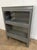 A substantial vintage industrial barrister bookcase or display cabinet constructed entirely of steel and finished in a...