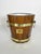 An elegant vintage wooden ice bucket, banded in polished brass and featuring two side handles with metal rings. Its design...