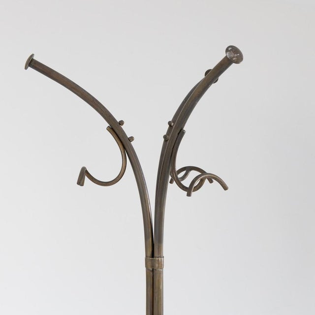 The elegant, curved design recalls mid-century style, with six upper hooks and additional lower supports for hanging...