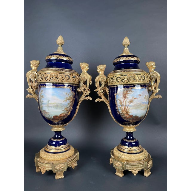 19th Century French Sèvres-style porcelain and gilt bronze mounted urns The urns have cobalt blue porcelain bodies,...