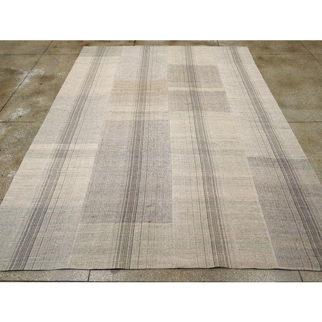 This mid-20th century Turkish Flatweave Kilim rug, features a softly muted palette and a subtle interplay of vertical and...