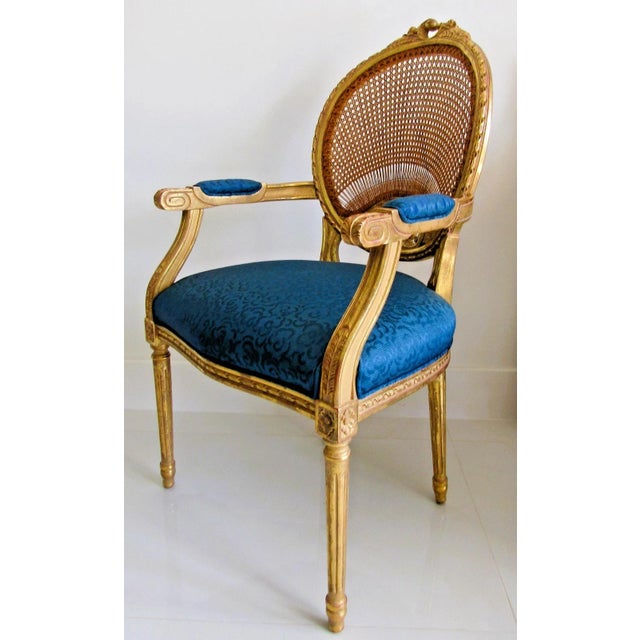 This French Louis XVI Style Fauteuil Chair features a beautiful giltwood frame with intricate carvings, complemented by a...