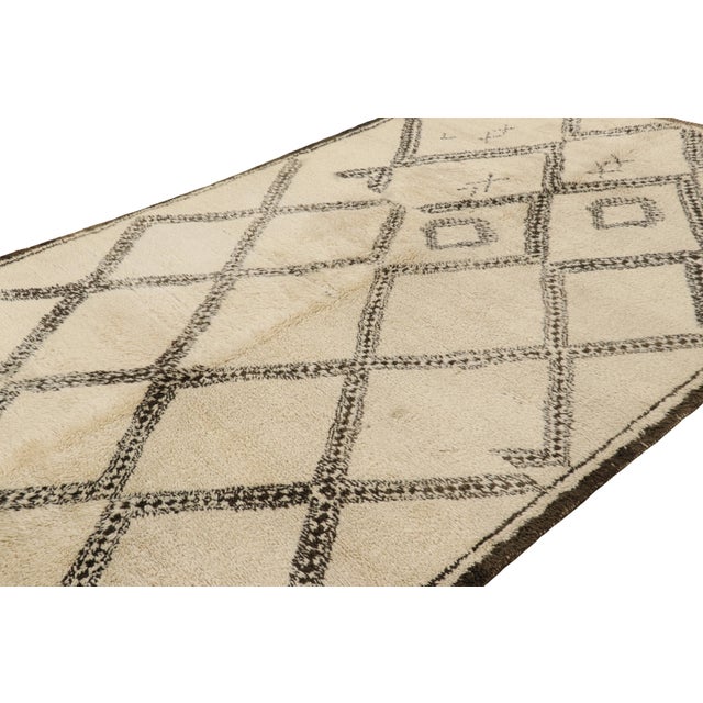 Hand-knotted in wool and originating from Morocco circa 1950-1960, this 7x12 vintage Moroccan rug is an extremely rare...