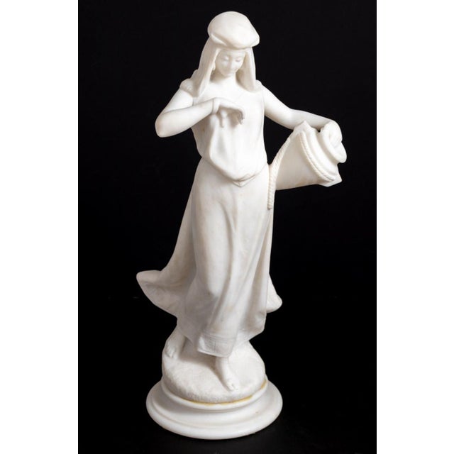 "The Water Carrier" White Marble Sculpture, depicting a standing figure holding a water vessel, on a socle. 22" H x 7" W x...