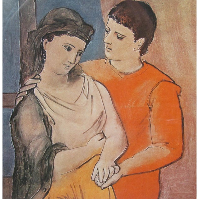 A vintage framed art print after Pablo Picasso’s “The Lovers,” (Les Amoureux or Los Amantes) presented with a soft blush-...