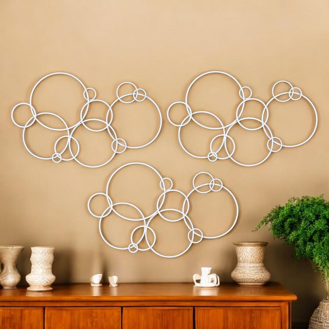 Get creative with your wall decor. This group of three circular metal wall sculptures can be arranged in many ways....