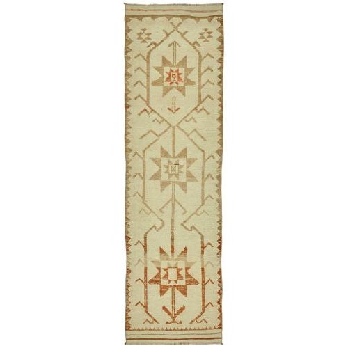 This exquisite runner rug is a rare example of tribal craftsmanship, hand-knotted by the women of the Herki tribe during...