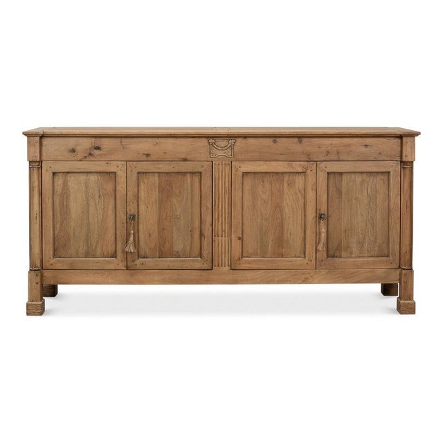 A long, low walnut case brings a settled horizontal presence to the room. Four recessed-panel doors line up in pairs...