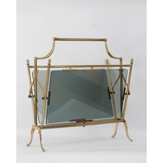 Decorative brass magazine rack, Italy, 1950s-1960s. Made of solid brass and smoked glass. It is heavy and very stable. No...