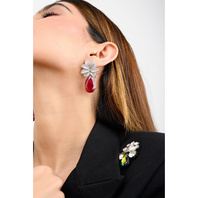 Bring feminine elegance to any outfit with these 925 sterling silver floral CZ drop earrings. Featuring a mix of pear and...