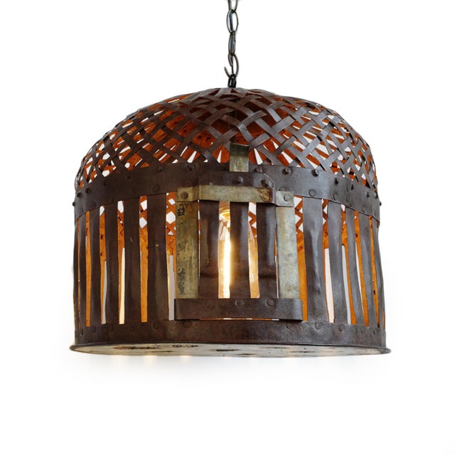 Vintage Indian iron cage basket thoughtfully repurposed into a one-of-a-kind pendant light, celebrating the raw beauty of...