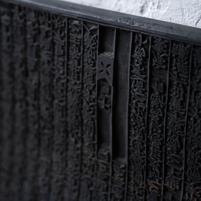 Rectangular hardwood printing block carved with Hanja sutra text in repeating relief columns, brass-fitted tall frame,...