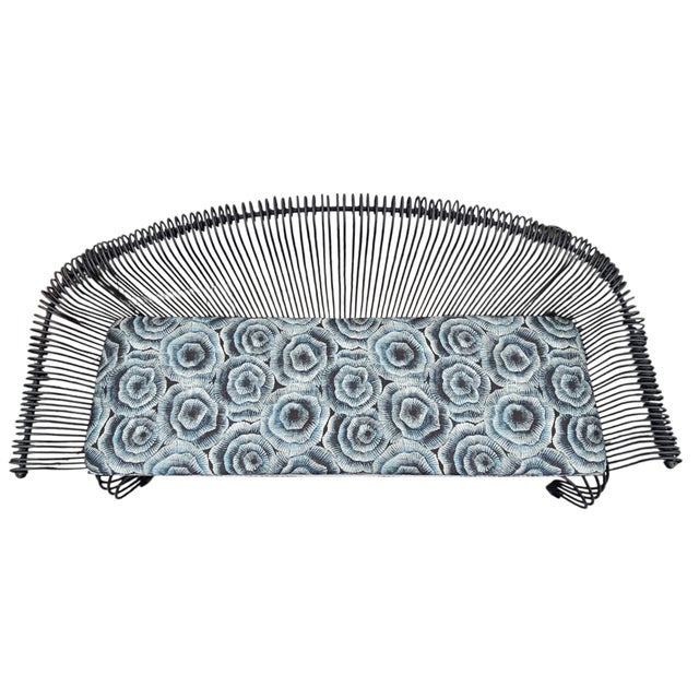 Very heavy wrought iron bench with graceful lines of French Country style. The seat has been reupholstered with a braded...