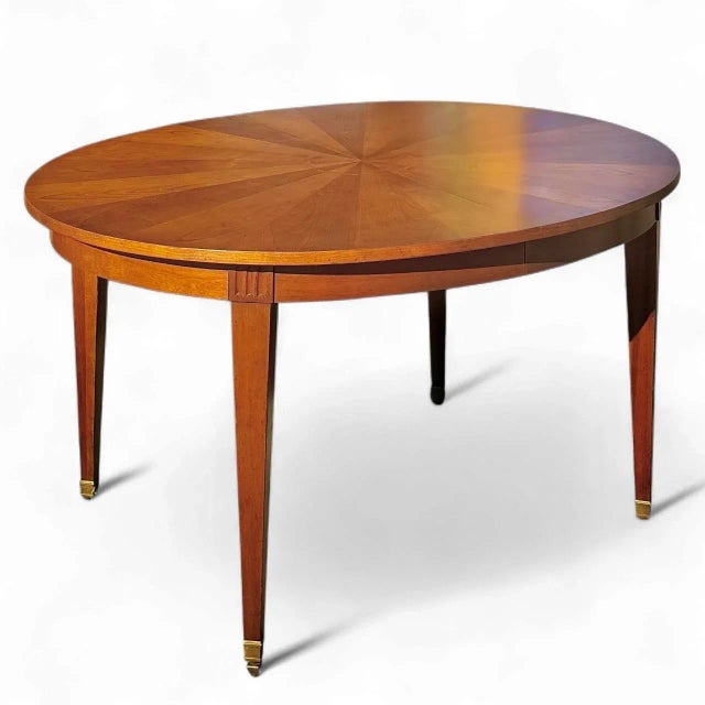 Date: Late 1950s Style: Louis XVI Material: Cherry/Brass Manufacturer: Baker Furniture Co. An oval dining table by Baker...