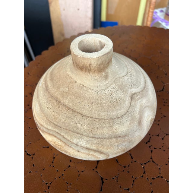 This unique item is a Wood Vase, characterized by its natural grain patterns and lightweight feel it could be paulownia...