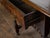 An English carved geometric front oak side table from the 19th century, with single drawer, bobbin legs, H-form cross...