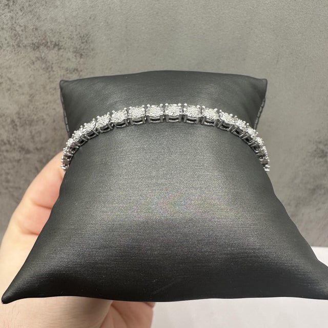 This classic diamond tennis bracelet in sterling silver features 0.25 carats total weight of natural I, I quality round...