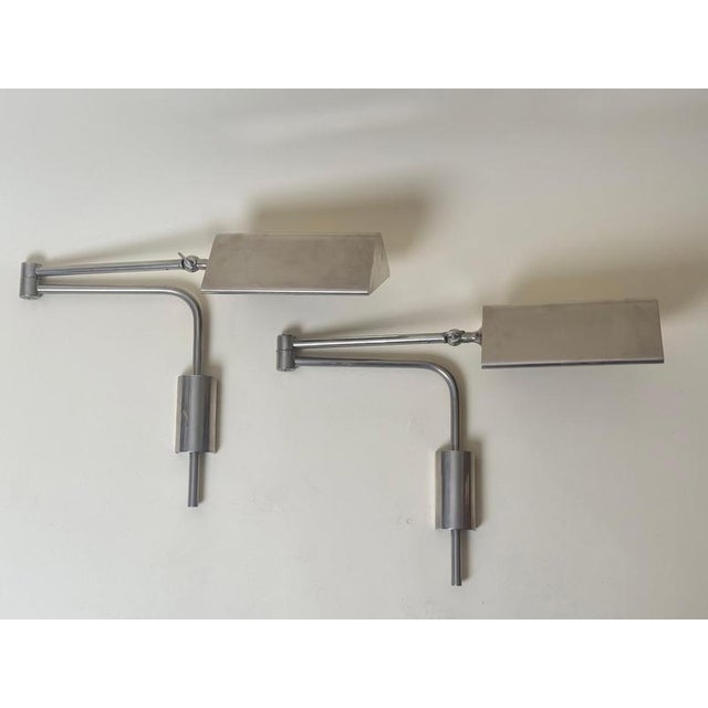 A refined pair of adjustable wall lights by Florian Schulz, Germany, dated March 1993. Executed in nickel-plated metal,...