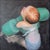 Figurative Adrift In The Tide by Fikriye Oz | Oil On Wood Painting of a baby in a green flotation device. For Sale - Image 3 of 3