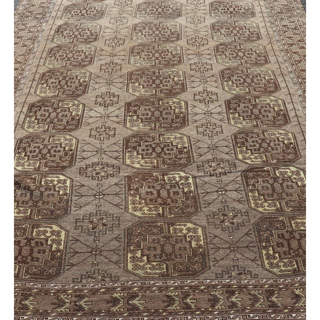 This Turkomen Ersari rug has been hand-knotted in the finest wool. The rug features a repeating Gul design throughout the...