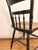 Classic Hitchcock chair featuring a deep black finish with traditional gold stenciled detailing and turned spindle back....