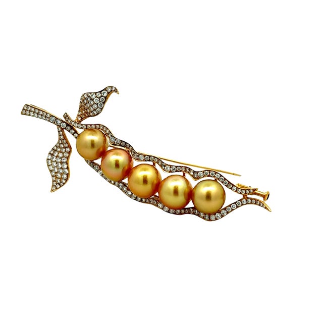 A striking brooch featuring five AAA South Sea pearls. They each have an intense golden color and measure over 10mm each....