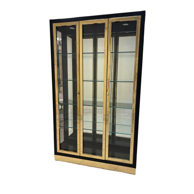 This impressive black lacquer and brass display case exemplifies the luxurious, architectural styling popularized by...