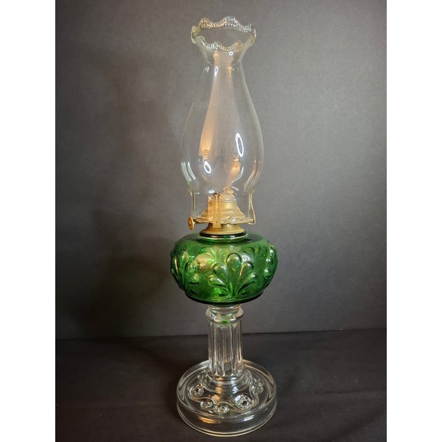 This exceptional Victorian-era composite kerosene stand lamp features a vibrant emerald green pressed glass font with...