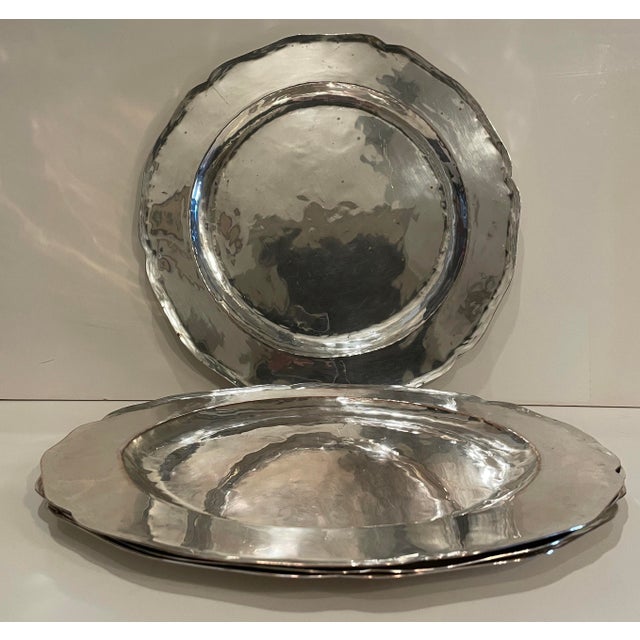 A set of four silver on copper Arts & Crafts hammered chargers. Silver on thin copper with scalloped edges and copper...